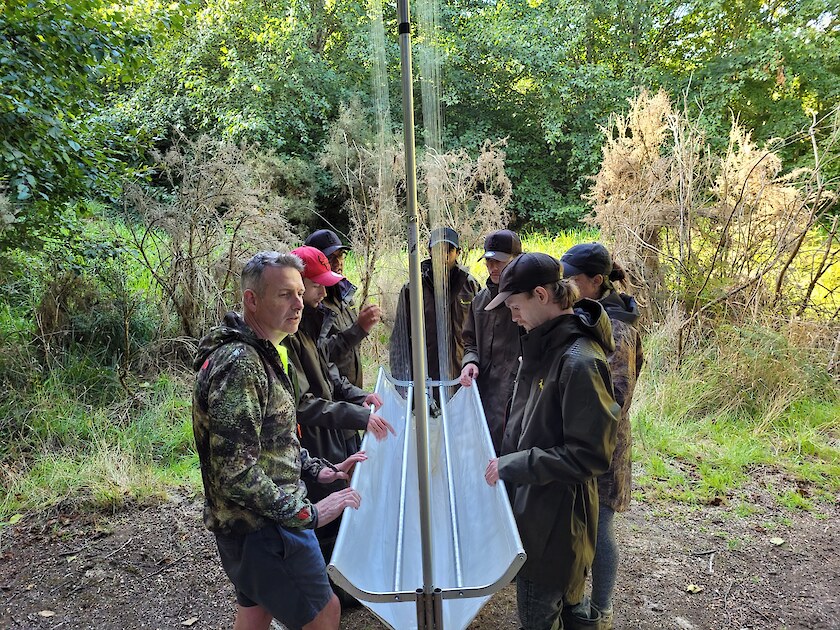 Ian explaining how to set up the Harp traps. The tauira helping to put these together and place them.
